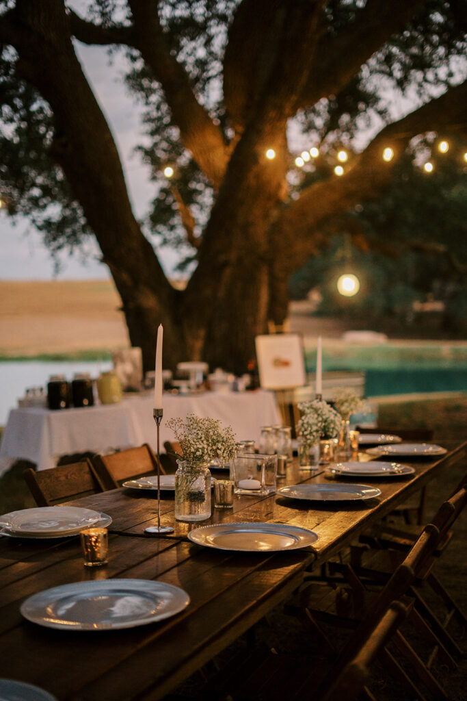 under the oaks, texas wedding venue, wedding rehearsal, texas bride, one more night, shiner texas, oak trees, bistro lights, dinner set up, outdoor dinner set up