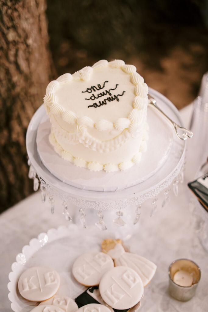 under the oaks, texas wedding venue, wedding rehearsal, texas bride, one more night, shiner texas, oak trees, bistro lights, dinner set up, outdoor dinner set up, one day away cake